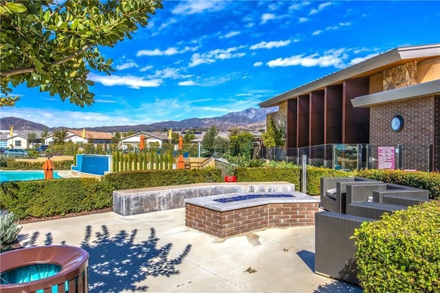 view of home's community featuring a patio area, a mountain view, and fence