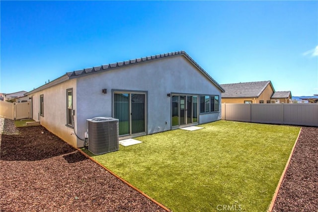 rear view of property featuring cooling unit, a yard, a fenced backyard, and stucco siding