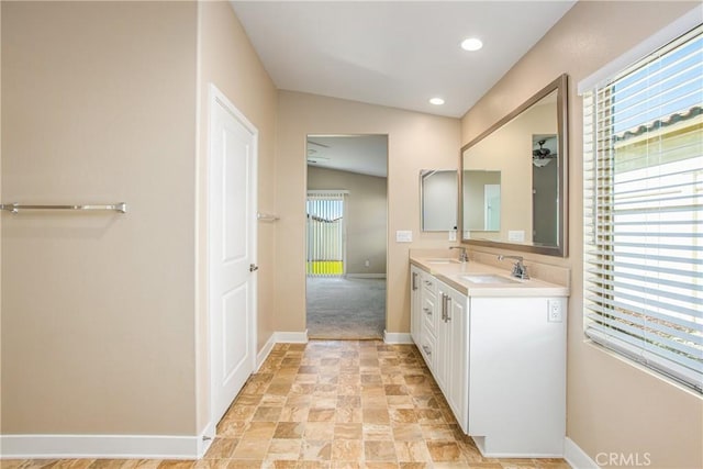 1567 Park Haven Dr, Beaumont, CA 92223 - bathroom featuring baseboards, double vanity, stone finish flooring, and recessed lighting