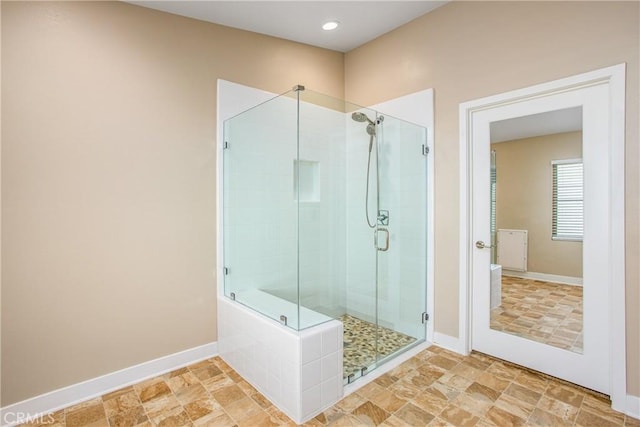 bathroom featuring baseboards and a stall shower