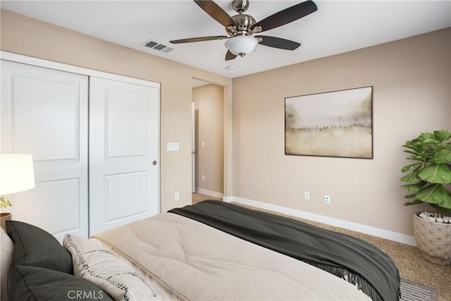 carpeted bedroom with visible vents, baseboards, a ceiling fan, and a closet