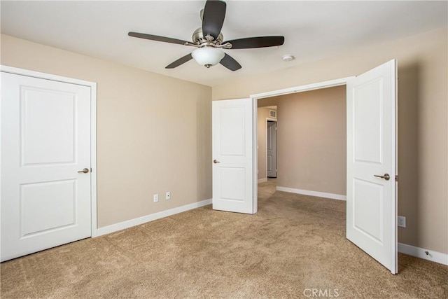 unfurnished bedroom featuring light colored carpet, baseboards, and a ceiling fan