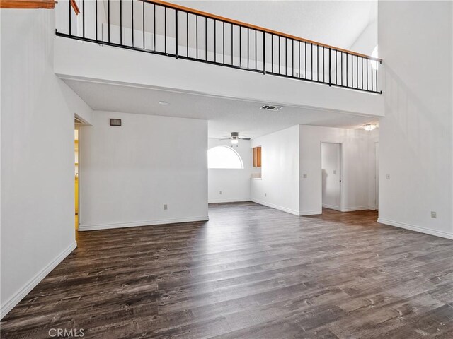 19246 Pine Way, Apple Valley, CA 92308 - unfurnished living room featuring a towering ceiling, ceiling fan, baseboards, and dark wood finished floors