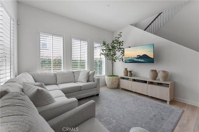 living area featuring baseboards and light wood finished floors