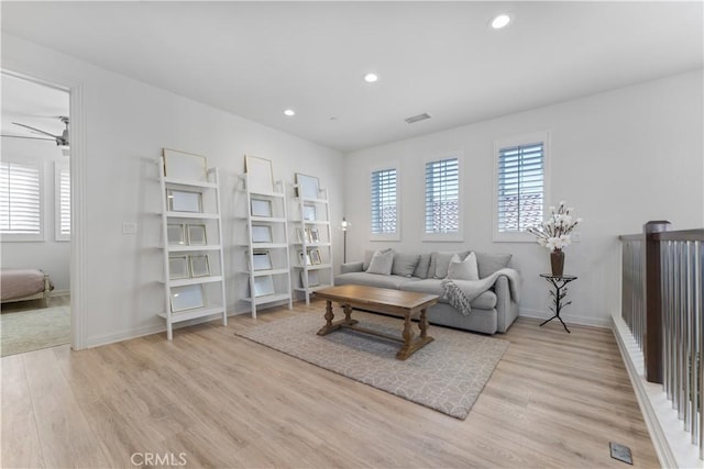living area featuring recessed lighting, light wood-type flooring, visible vents, and a healthy amount of sunlight