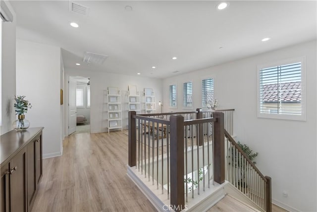 corridor with recessed lighting, visible vents, light wood finished floors, and an upstairs landing