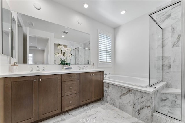 full bathroom featuring marble finish floor, visible vents, a marble finish shower, a sink, and a garden tub