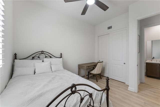 bedroom with light wood-style flooring, visible vents, a closet, and ceiling fan