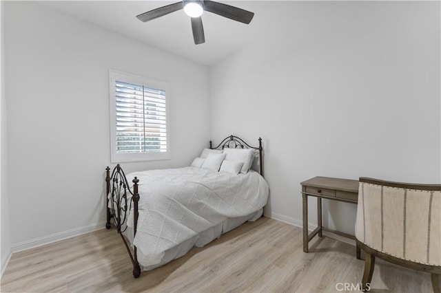 bedroom featuring baseboards, wood finished floors, and ceiling fan