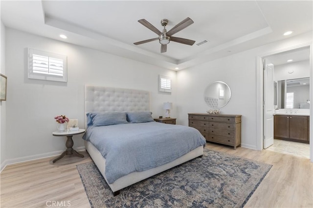 bedroom with recessed lighting, a raised ceiling, visible vents, and light wood finished floors
