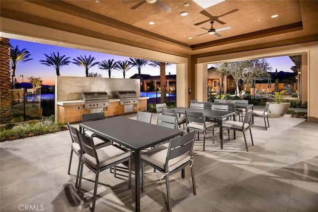view of patio / terrace with exterior kitchen, grilling area, outdoor dining space, and ceiling fan