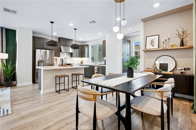 dining space with recessed lighting, light wood finished floors, and visible vents