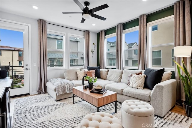 living room with baseboards, ceiling fan, wood finished floors, and recessed lighting
