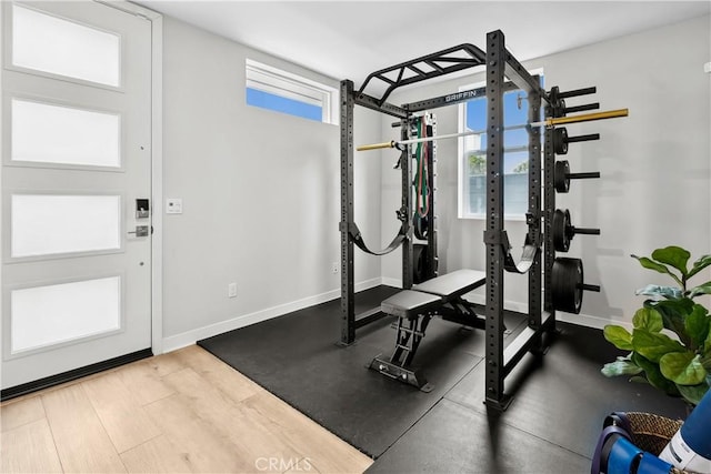 workout area featuring baseboards and wood finished floors