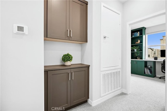 corridor featuring baseboards, visible vents, and light carpet