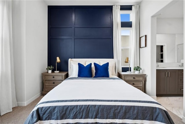 bedroom with baseboards and ensuite bathroom
