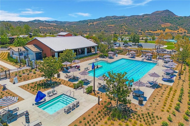 pool featuring a patio, a mountain view, and fence