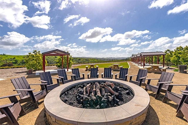 view of patio / terrace with a fire pit, a gazebo, and fence