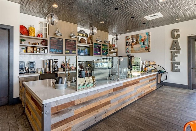 bar with an ornate ceiling, hardwood / wood-style flooring, baseboards, visible vents, and decorative light fixtures