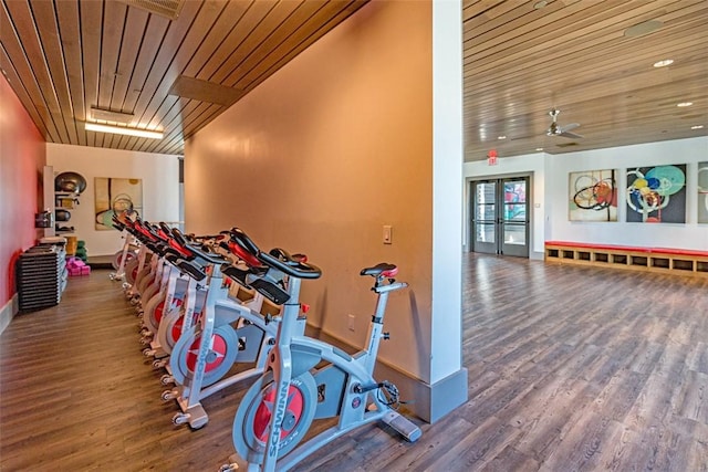 workout area featuring baseboards, wood finished floors, a ceiling fan, french doors, and wooden ceiling