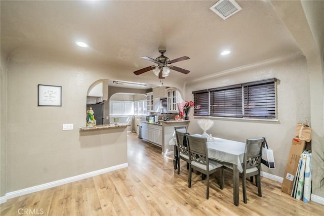 541 Elm Ave, Inglewood, CA 90301 - dining area featuring arched walkways, visible vents, light wood-style flooring, and a ceiling fan