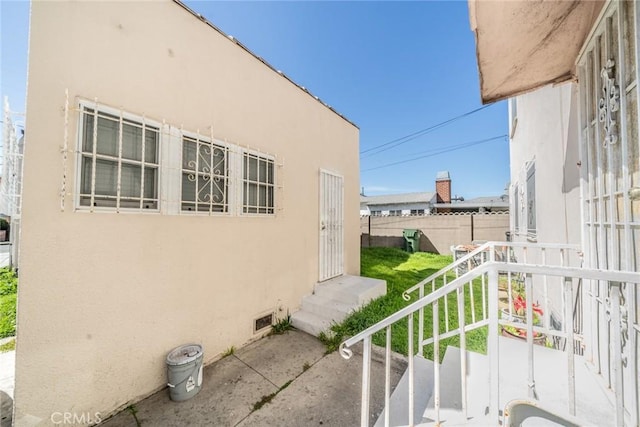 541 Elm Ave, Inglewood, CA 90301 - view of property exterior with stucco siding, entry steps, and fence