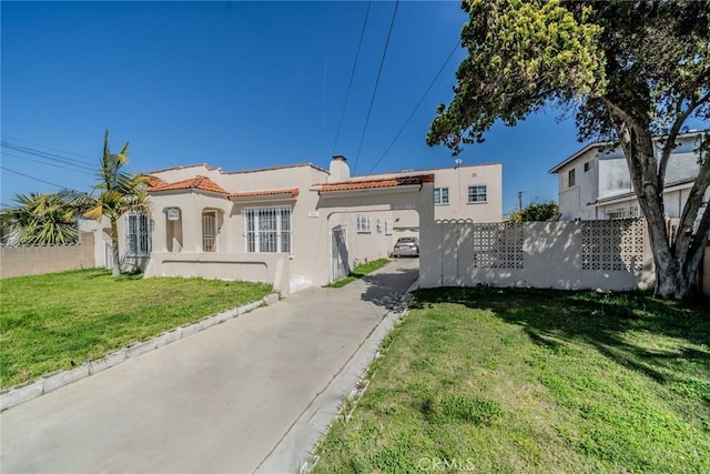 541 Elm Ave, Inglewood, CA 90301 - exterior space featuring a front lawn, fence, a tiled roof, stucco siding, and a chimney