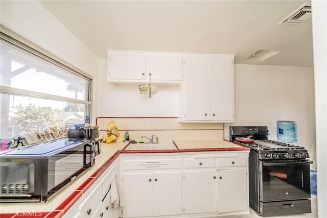 541 Elm Ave, Inglewood, CA 90301 - kitchen featuring visible vents, black appliances, tasteful backsplash, tile countertops, and white cabinets