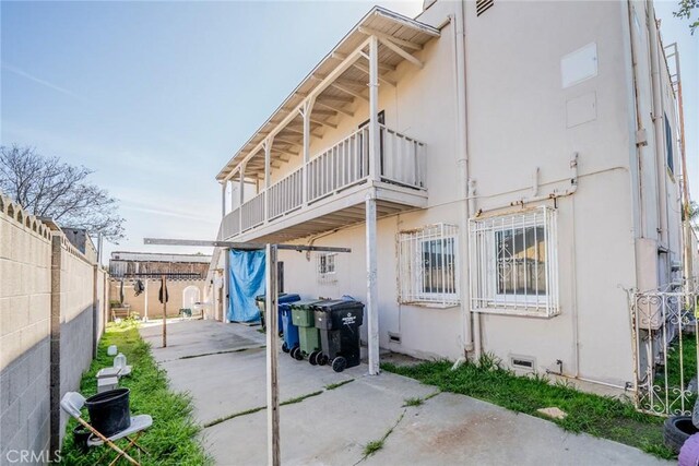 541 Elm Ave, Inglewood, CA 90301 - rear view of house featuring crawl space, stucco siding, a balcony, and fence