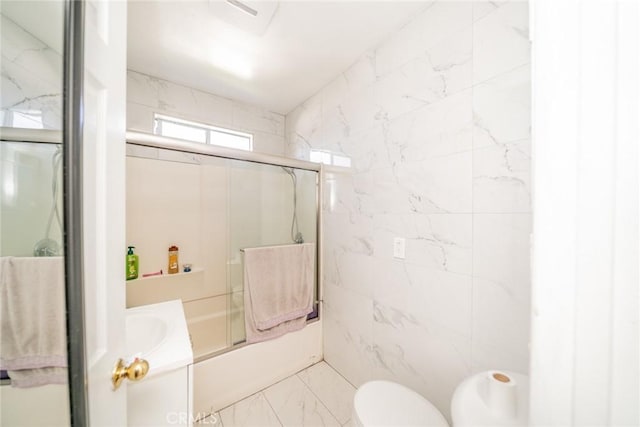541 Elm Ave, Inglewood, CA 90301 - bathroom featuring tile walls, toilet, marble finish floor, and enclosed tub / shower combo