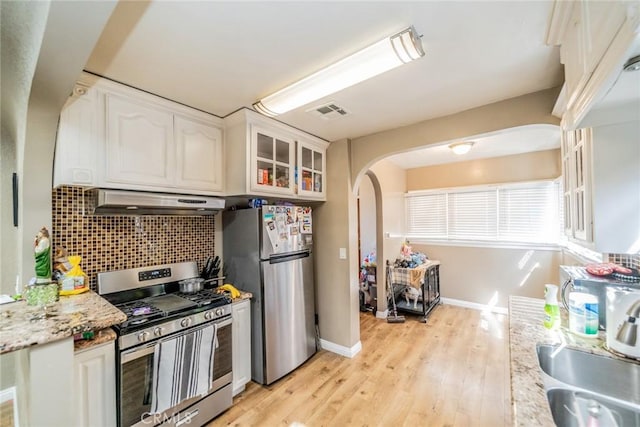 541 Elm Ave, Inglewood, CA 90301 - kitchen with visible vents, under cabinet range hood, backsplash, arched walkways, and appliances with stainless steel finishes