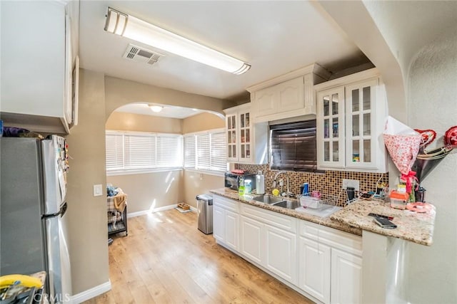 541 Elm Ave, Inglewood, CA 90301 - kitchen featuring light wood-type flooring, visible vents, tasteful backsplash, freestanding refrigerator, and arched walkways