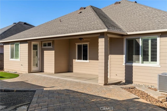 back of house featuring cooling unit, a patio area, roof with shingles, and fence