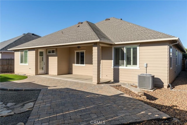 back of house featuring a patio area, central AC unit, a shingled roof, and fence