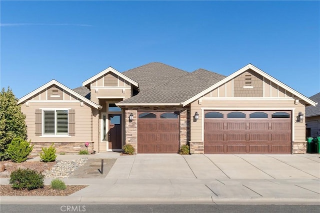 single story home featuring stone siding, concrete driveway, and a garage