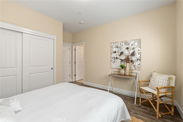 bedroom featuring wood finished floors, a closet, and baseboards