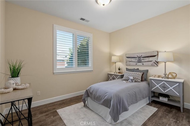 bedroom with wood finished floors, visible vents, and baseboards