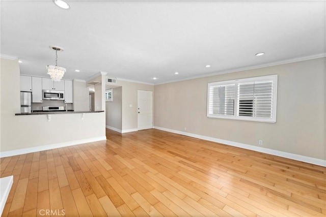 unfurnished living room with crown molding, baseboards, recessed lighting, light wood-style flooring, and an inviting chandelier