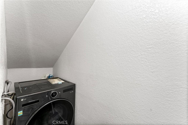 laundry room with laundry area, washer / clothes dryer, a textured wall, and a textured ceiling