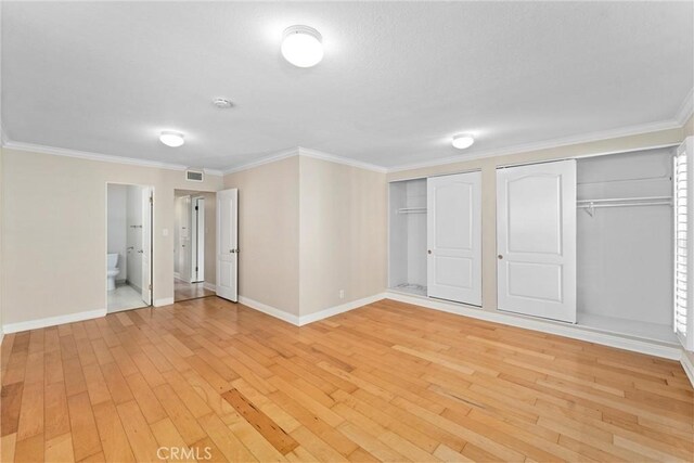interior space with visible vents, baseboards, light wood-style flooring, and ornamental molding