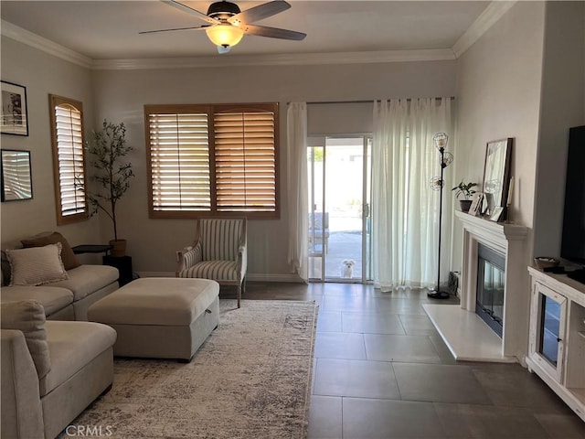 tiled living area with baseboards, ceiling fan, a premium fireplace, and ornamental molding
