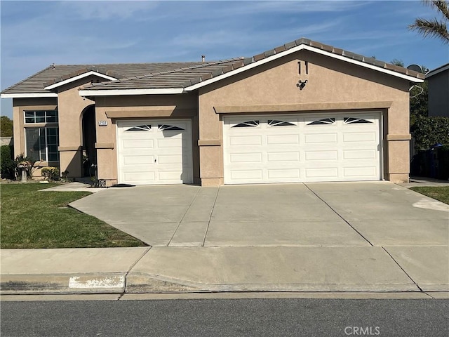 ranch-style home featuring a front yard, stucco siding, a garage, and concrete driveway