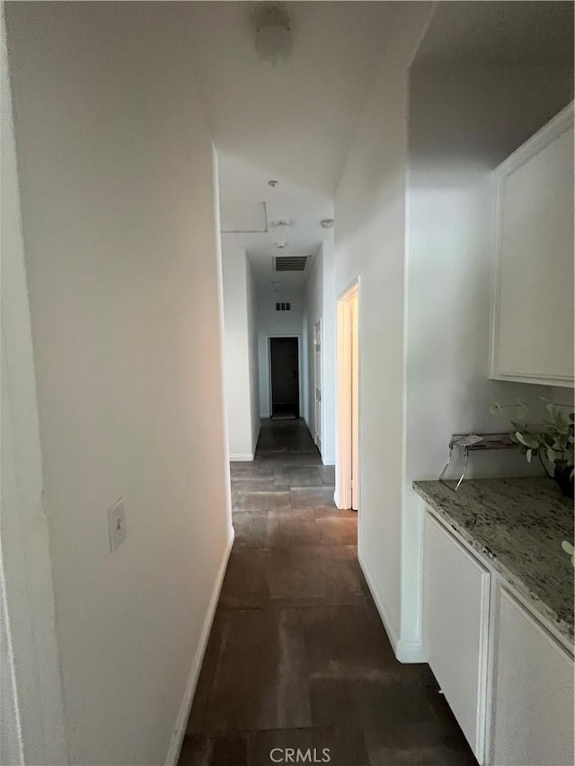 corridor with baseboards and visible vents
