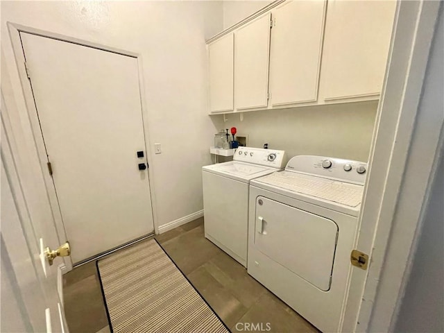 washroom with washing machine and clothes dryer, cabinet space, and baseboards