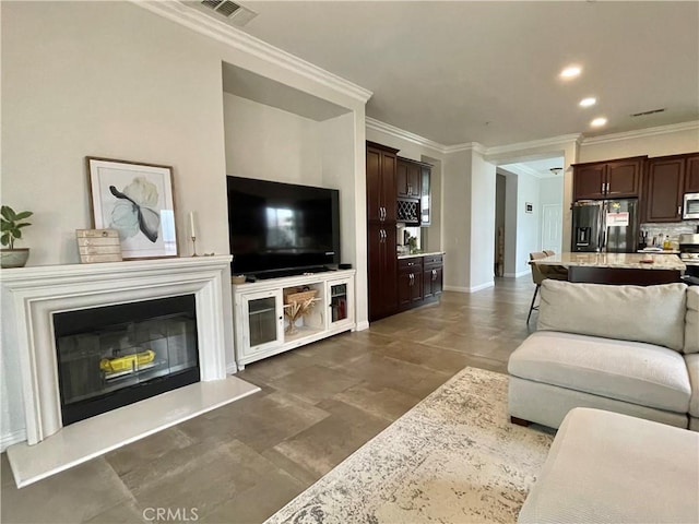 living room with baseboards, visible vents, crown molding, and recessed lighting