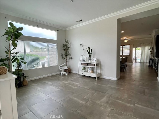 interior space featuring baseboards, ceiling fan, visible vents, and crown molding