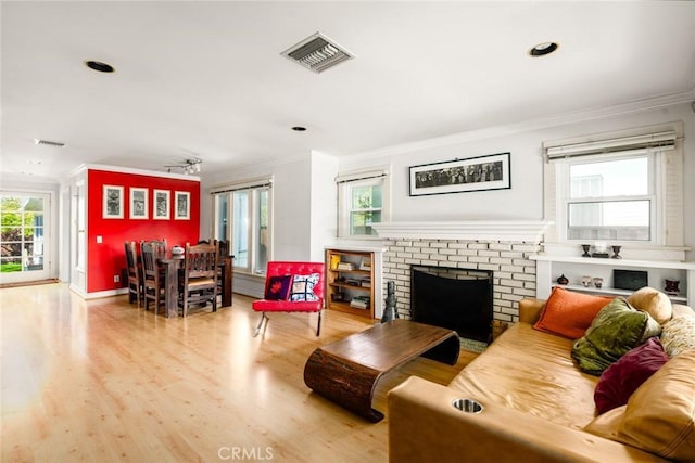 living room featuring visible vents, crown molding, and wood finished floors