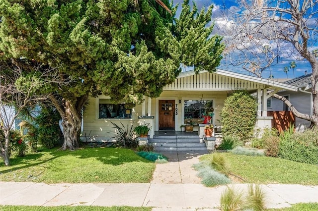 view of front facade featuring covered porch and a front yard