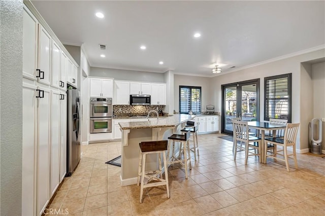 kitchen featuring tasteful backsplash, recessed lighting, appliances with stainless steel finishes, white cabinets, and crown molding