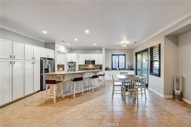 kitchen featuring white cabinetry, decorative backsplash, appliances with stainless steel finishes, light tile patterned flooring, and recessed lighting